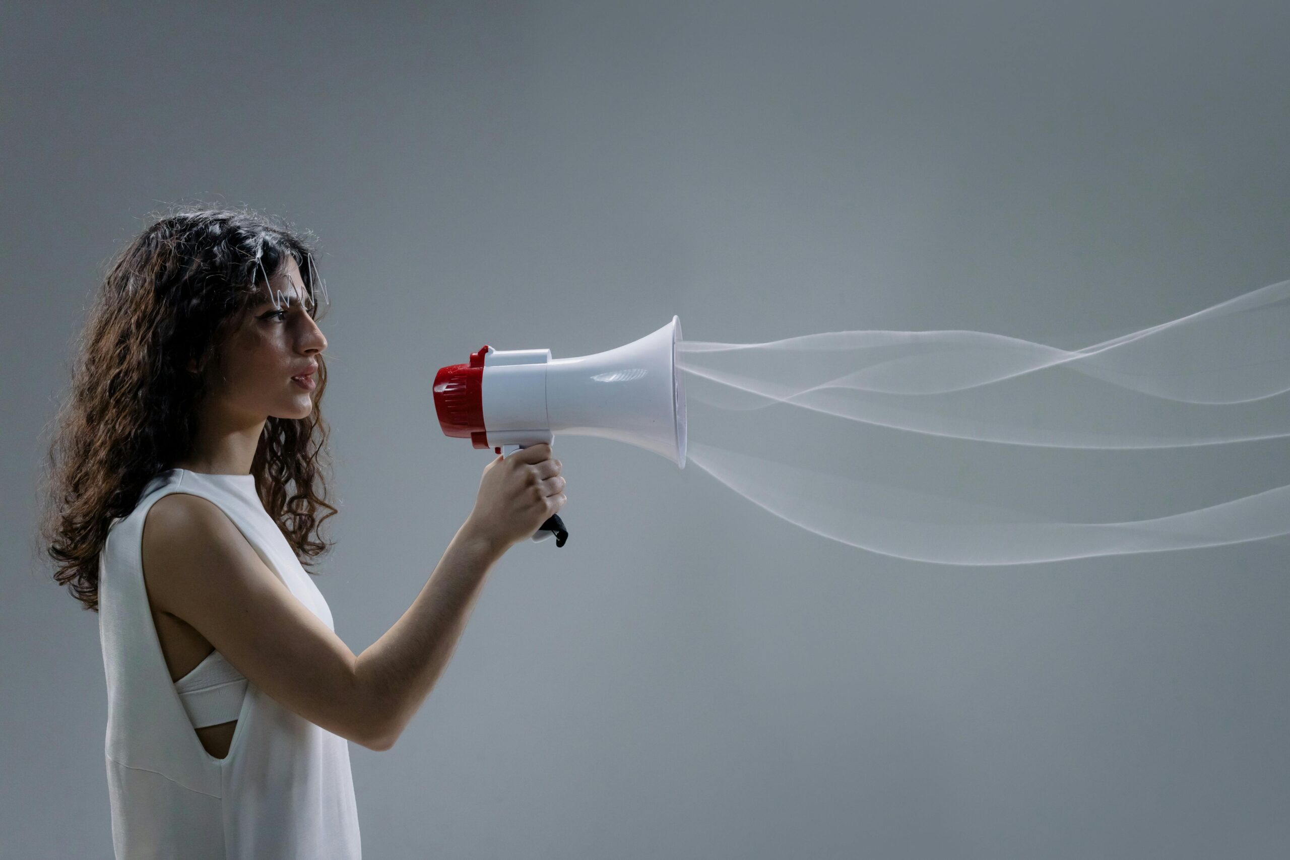 femme parlant dans un mégaphone, visualisation poétique des ondes sonores.